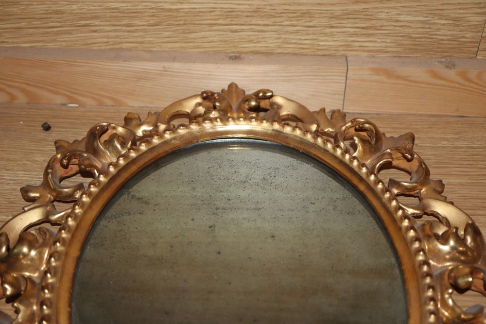 A pair of Venetian circular carved giltwood wall mirrors and another similar mirror